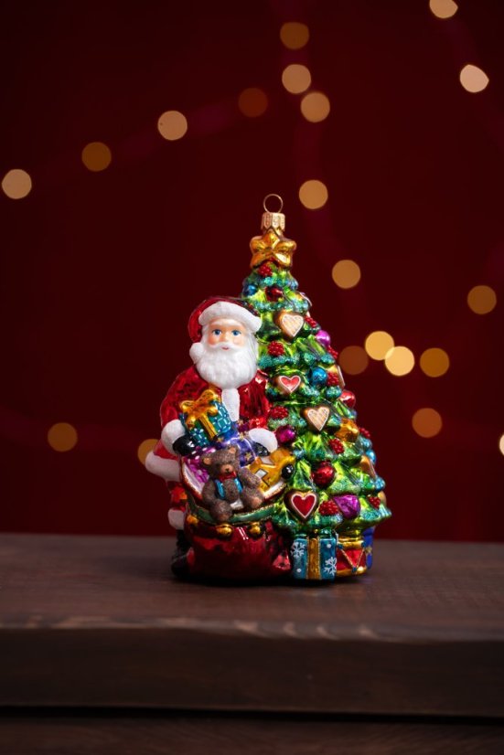 Collectible glass tree ornament Santa next to the tree